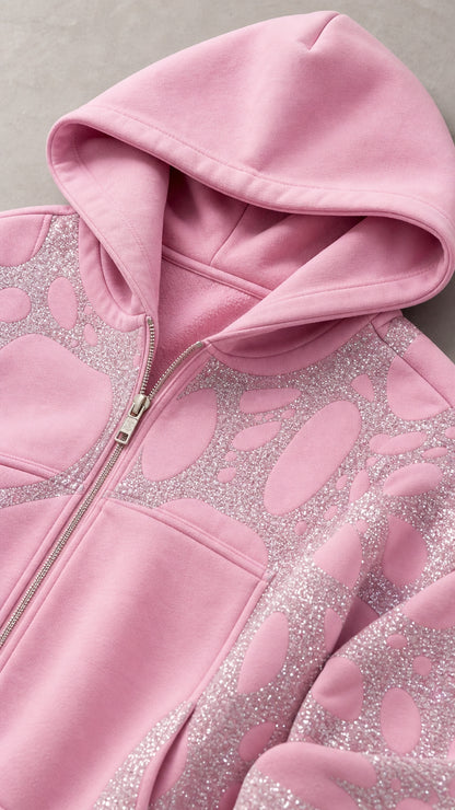 Close-up detail of light pink zip hoodie with hood and glitter pattern
