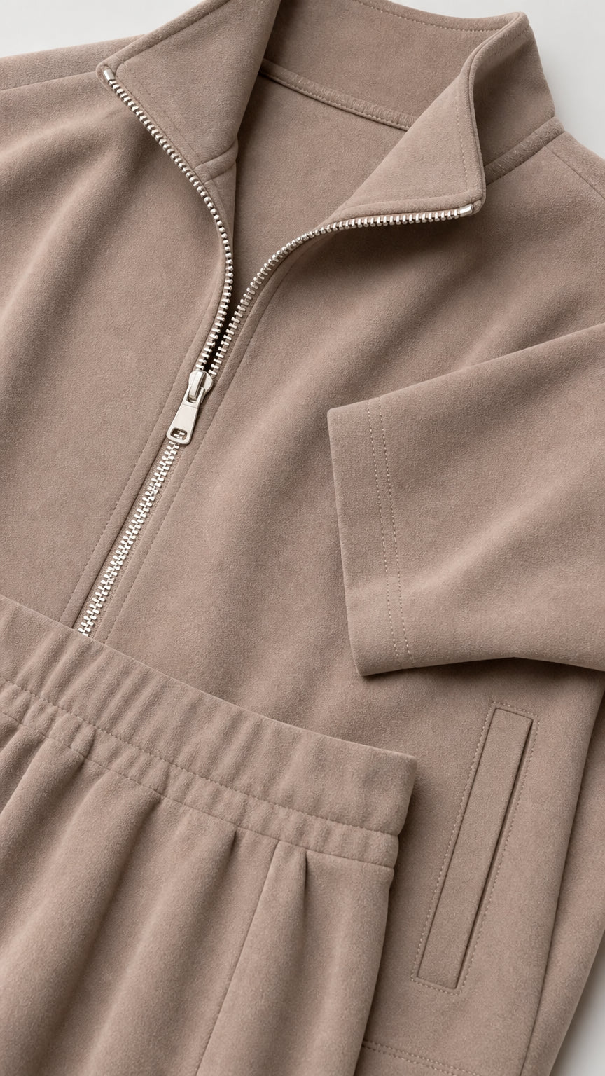 Close-up detail of taupe zipper and pocket construction