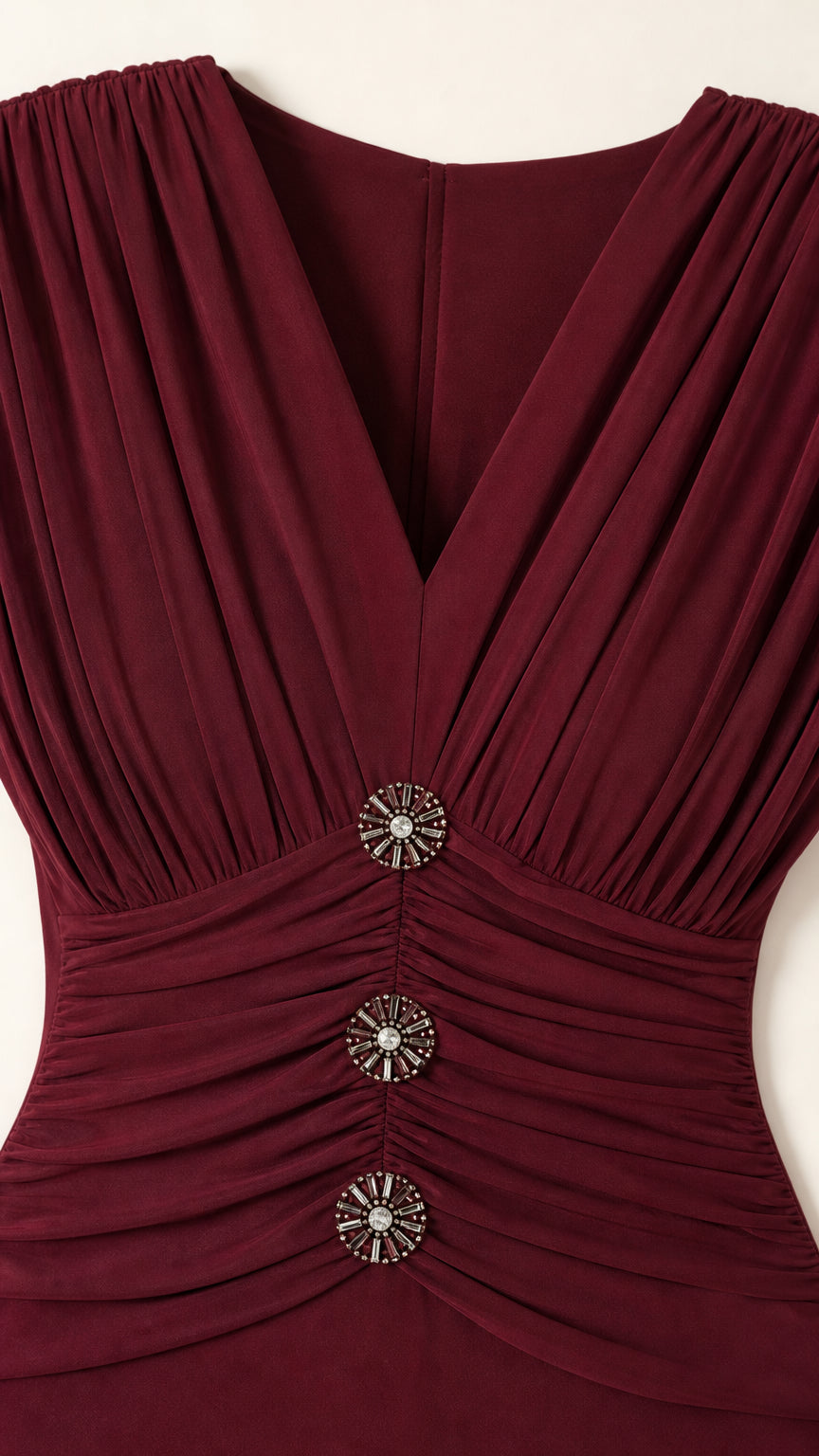 Close-up detail of pleated V-neckline and decorative crystal buttons