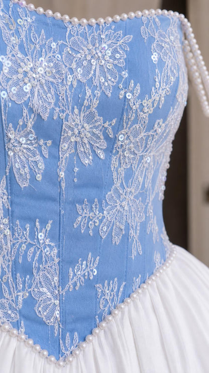 Close-up detail of lace embroidery and pearl trim on bodice