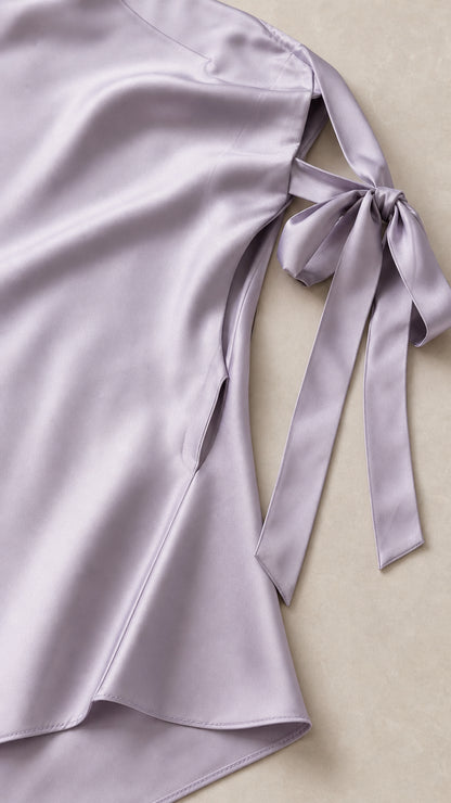 Close-up of fabric and shoulder tie detail on lavender satin dress