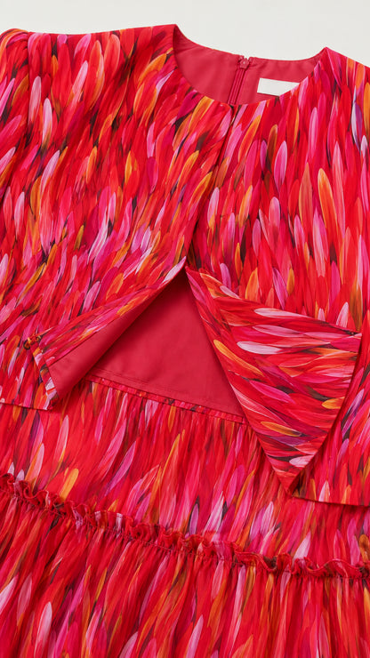 Close-up detail of the red abstract fabric and bodice construction