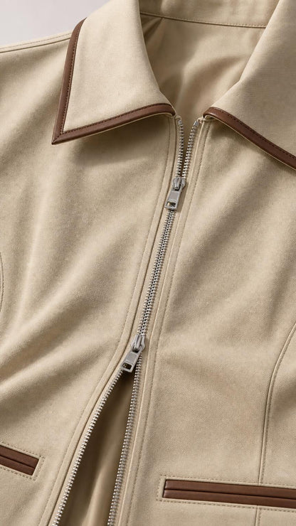 Close-up detail of zipper, collar, and contrast piping on khaki jacket