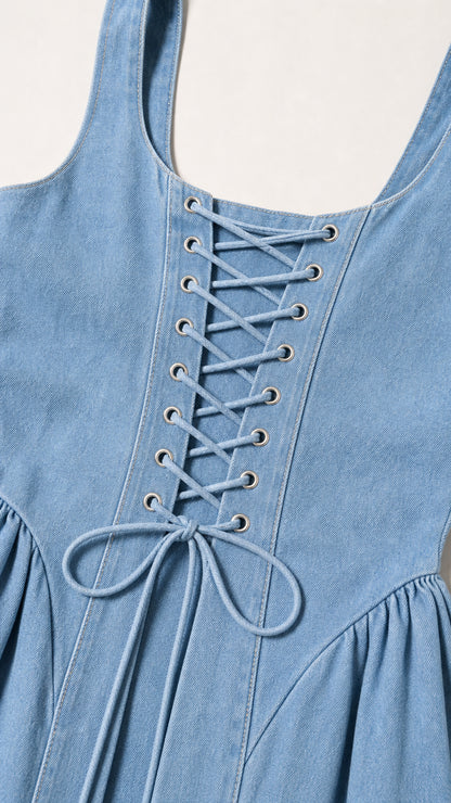 Close-up of the lace-up back grommet detail on light blue denim dress