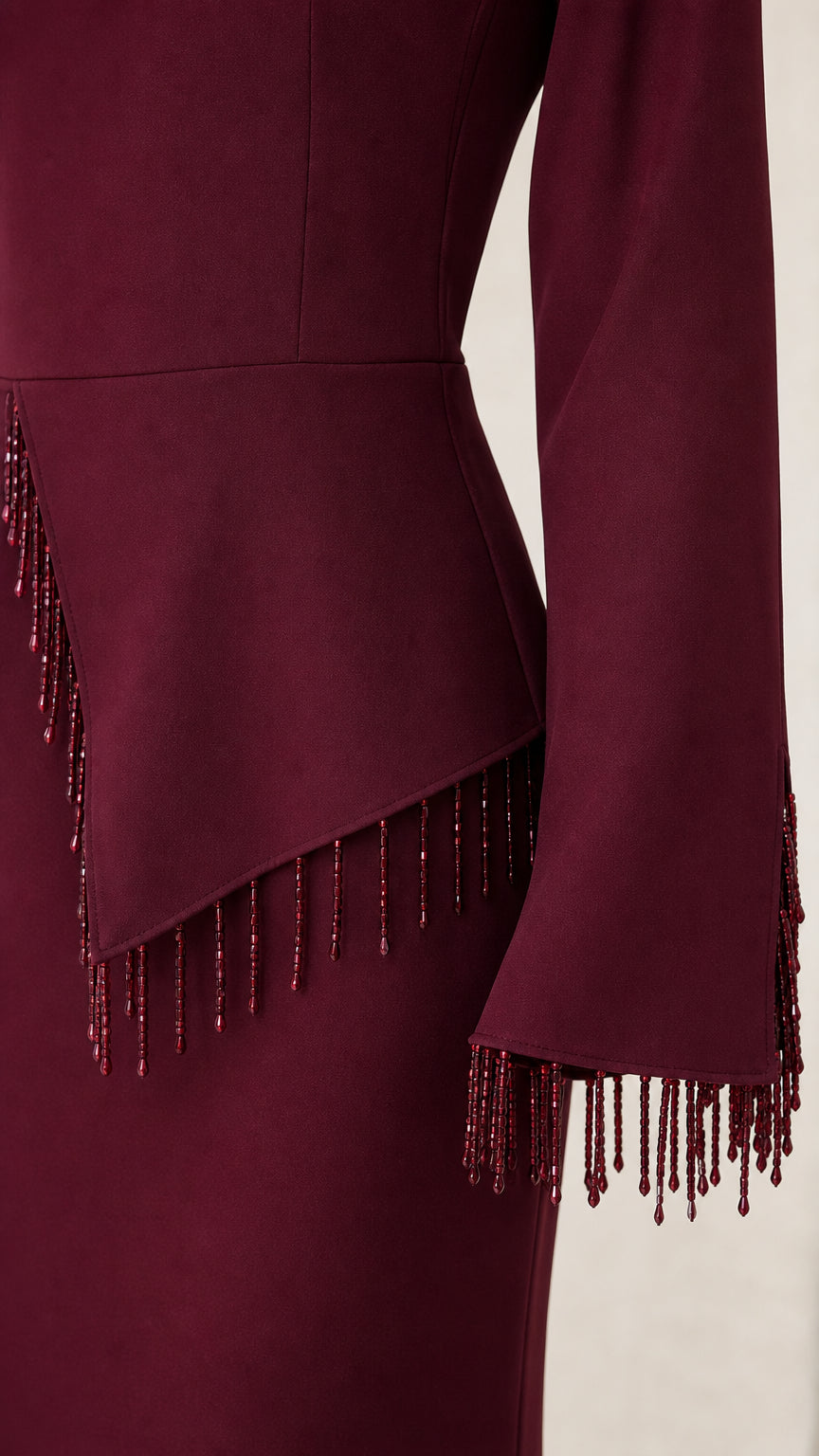 Close-up of beaded fringe trim along asymmetrical peplum waist and sleeve cuffs