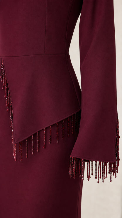 Close-up of beaded fringe trim along asymmetrical peplum waist and sleeve cuffs