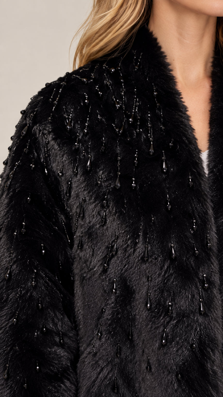 Close-up detail of black faux fur fabric with delicate beaded embellishments