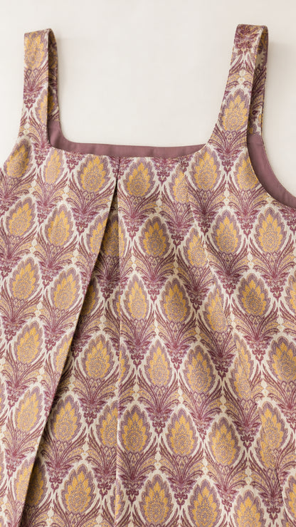 Close-up detail of square neckline and front pleat on damask printed fabric