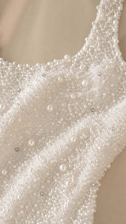Close-up detail shot of intricate faux pearl and bead embellishments on fabric