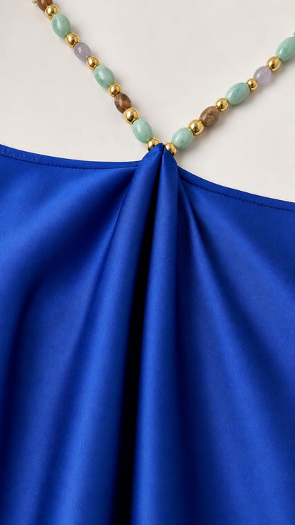 Close-up detail of multi-colored beaded hardware on dress strap