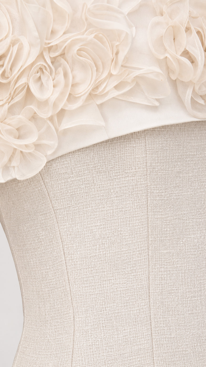 Close-up detail of 3D fabric rosettes on white dress bodice