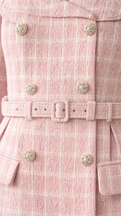 Close-up of buttons and belt detail on tweed dress
