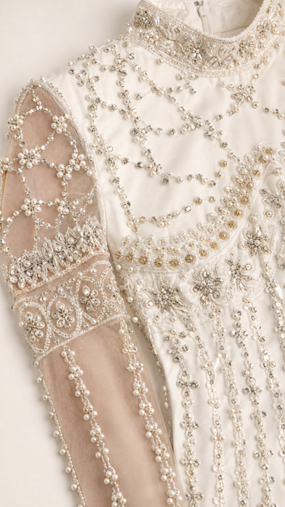 Close-up of intricate crystal and pearl beadwork on sheer sleeve