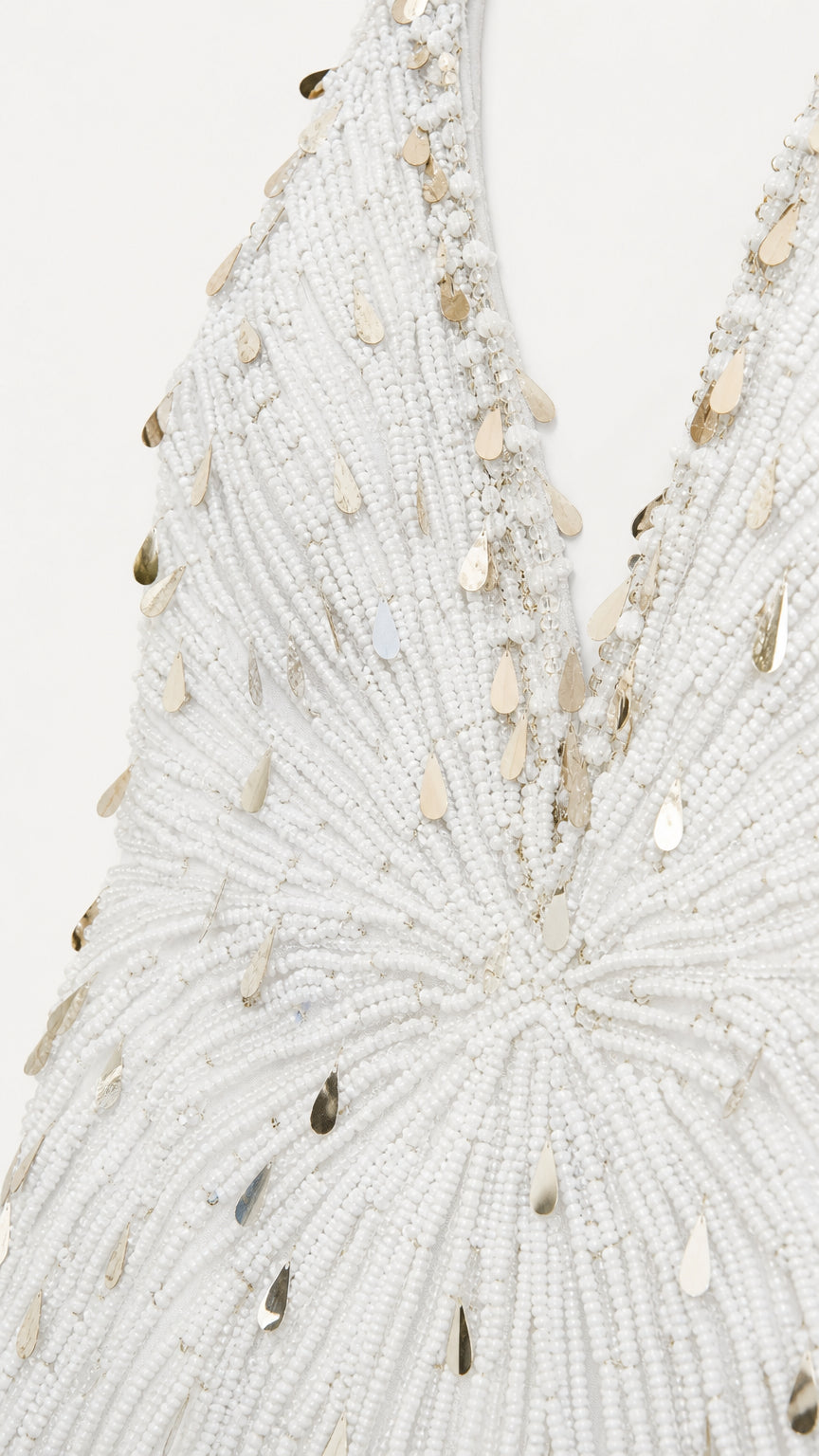 Close-up detail of intricate white seed bead and gold teardrop sequin embroidery