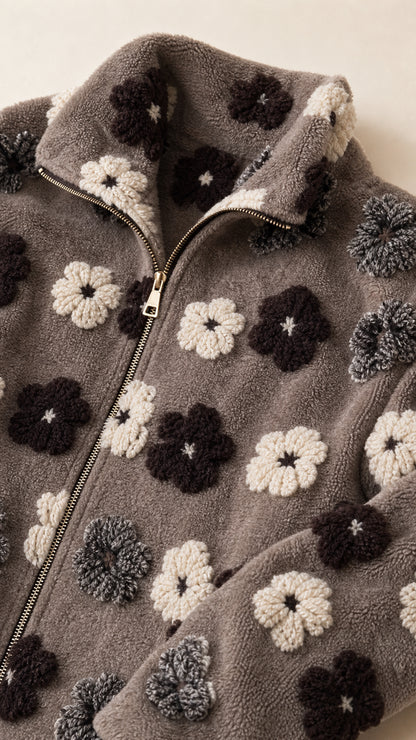 Close-up detail of zipper, collar, and 3D textured floral pattern on sherpa fleece fabric