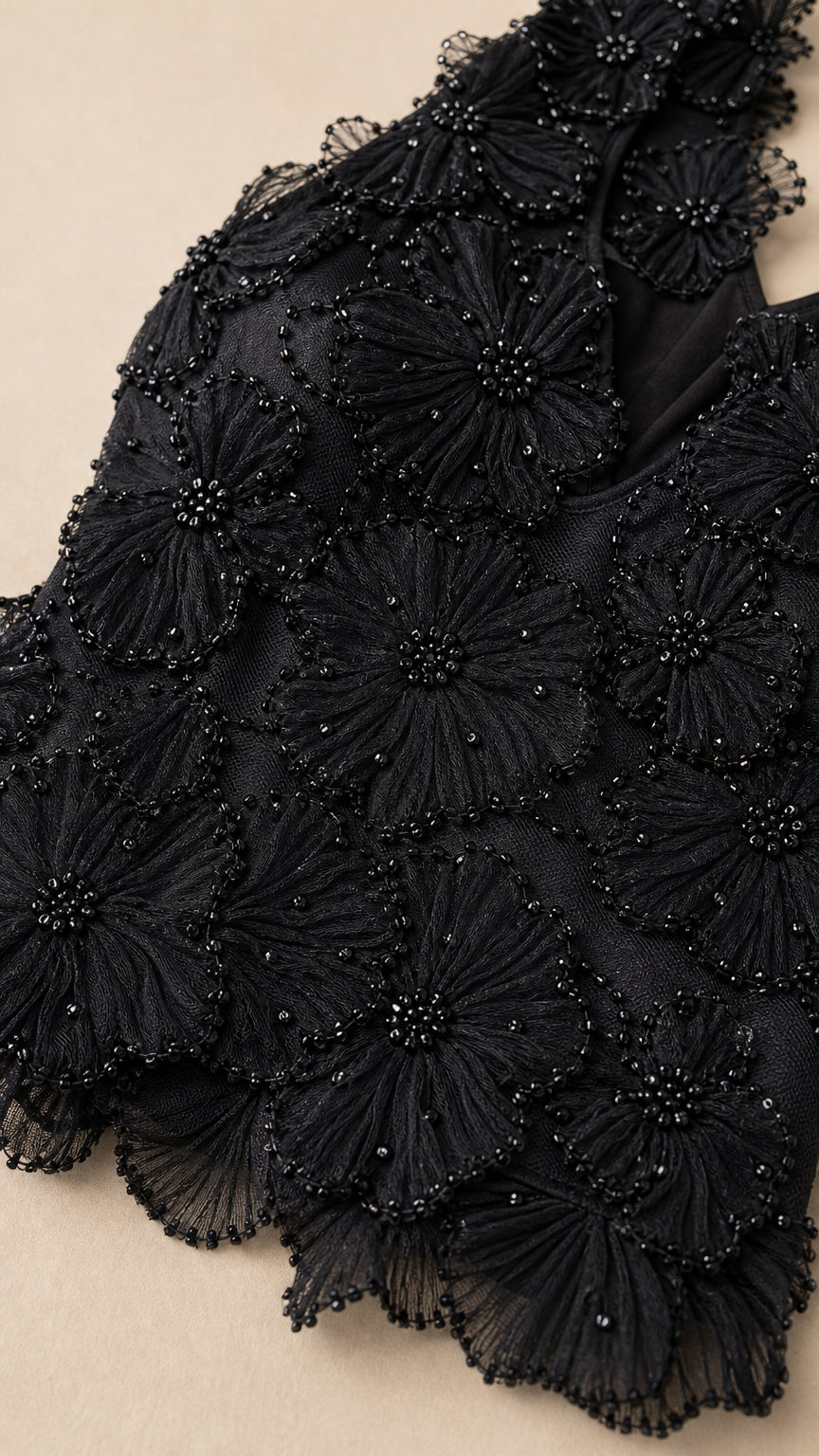 Close-up detail of black 3D floral petal applique and tonal bead embroidery