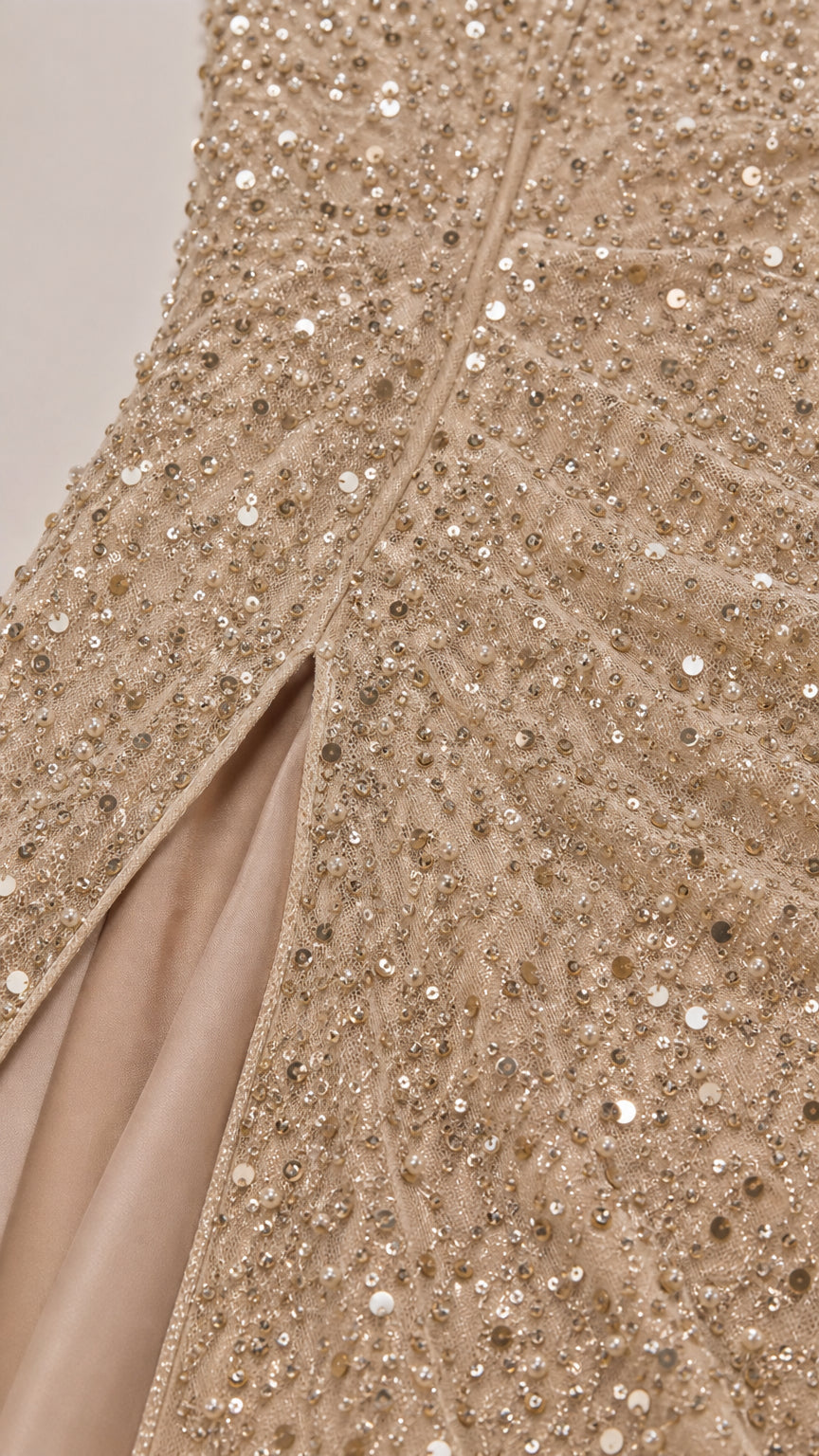 Close-up detail of champagne gold sequin embroidery and side slit construction