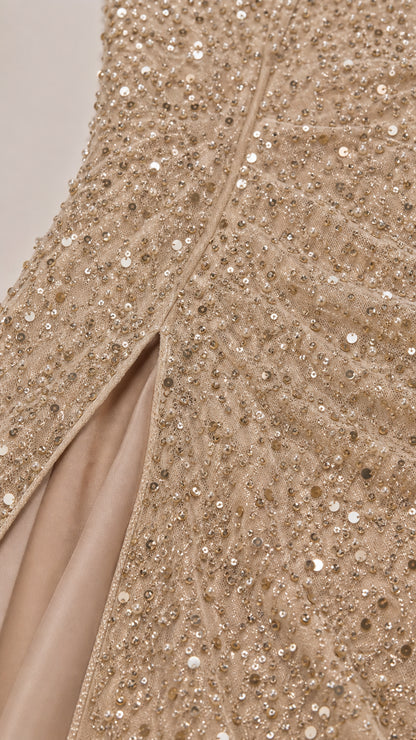 Close-up detail of champagne gold sequin embroidery and side slit construction