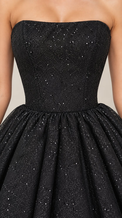 Close-up detail of black strapless fitted bodice with shimmering lace texture
