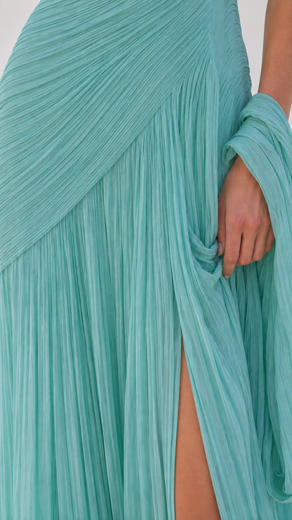 Close-up detail of aqua blue pleated fabric, drape, and side slit