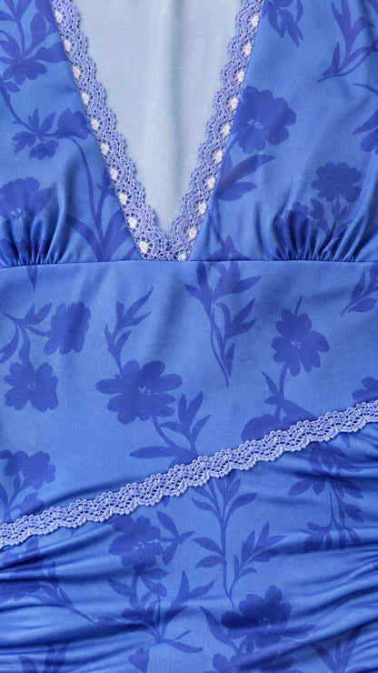 Close-up detail of lace trim and floral print on blue dress