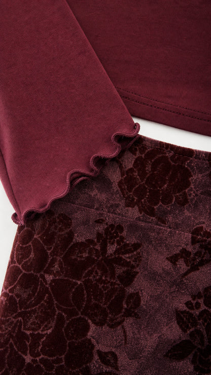 Close-up detail of lettuce-edge cuff and velvet floral skirt texture