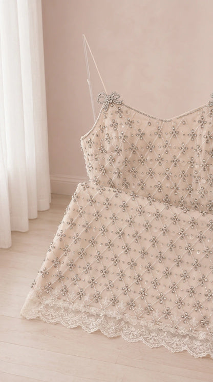 Close up of intricate lattice beading, lace hem, and bow strap detail