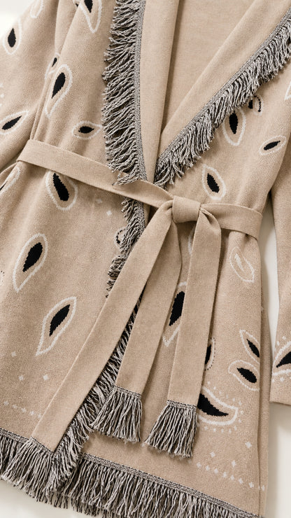 Close-up detail of fringe trim and belt on khaki cardigan