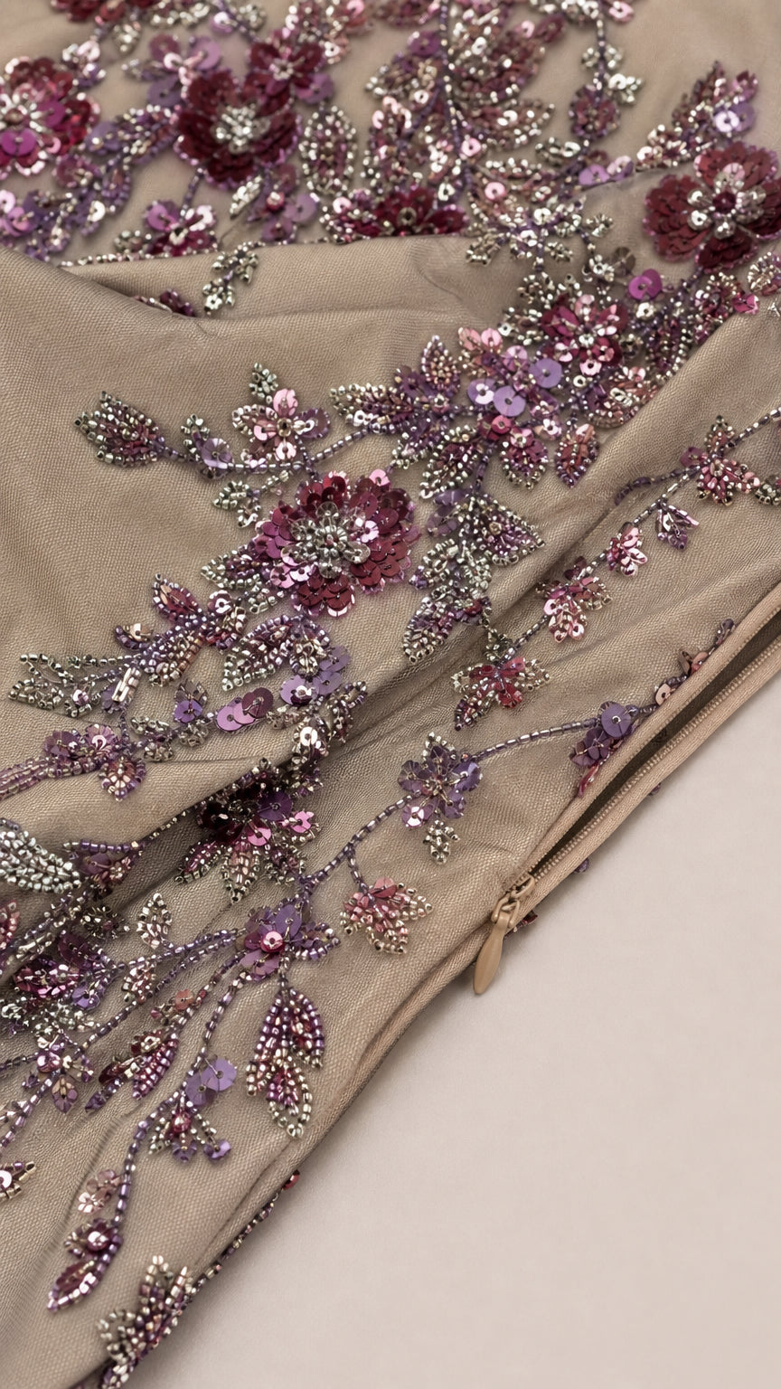 Close-up detail of floral beadwork, sequins, and concealed zipper closure