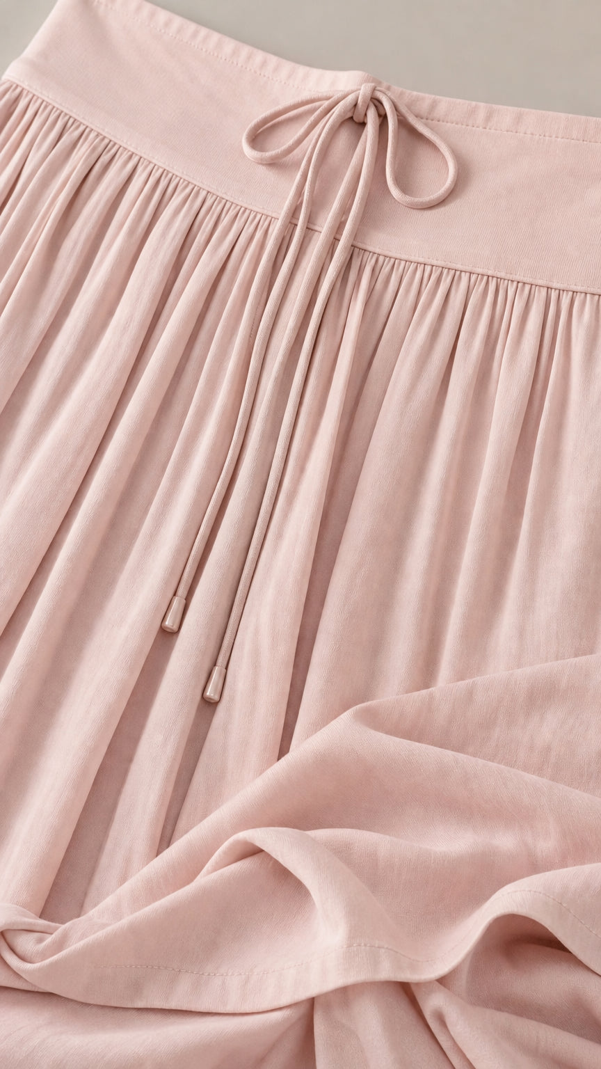 Close-up of pink pants drawstring waistband and soft fabric texture