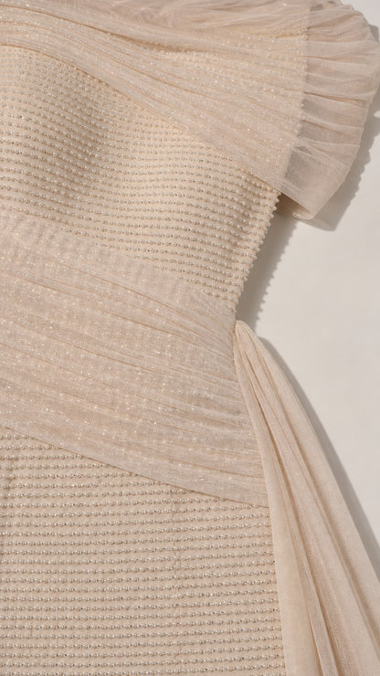 Close-up detail of textured fabric and ruched shoulder drape on evening gown