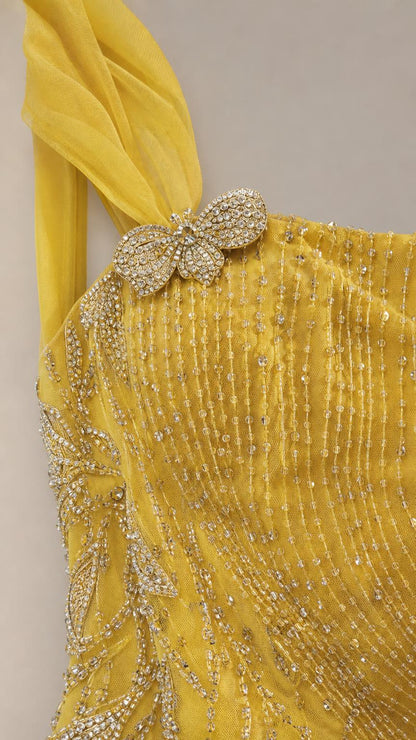 Close-up of crystal embellishment and beadwork on yellow dress