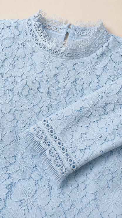 Close-up detail of lace pattern, mock neck, and cuffs