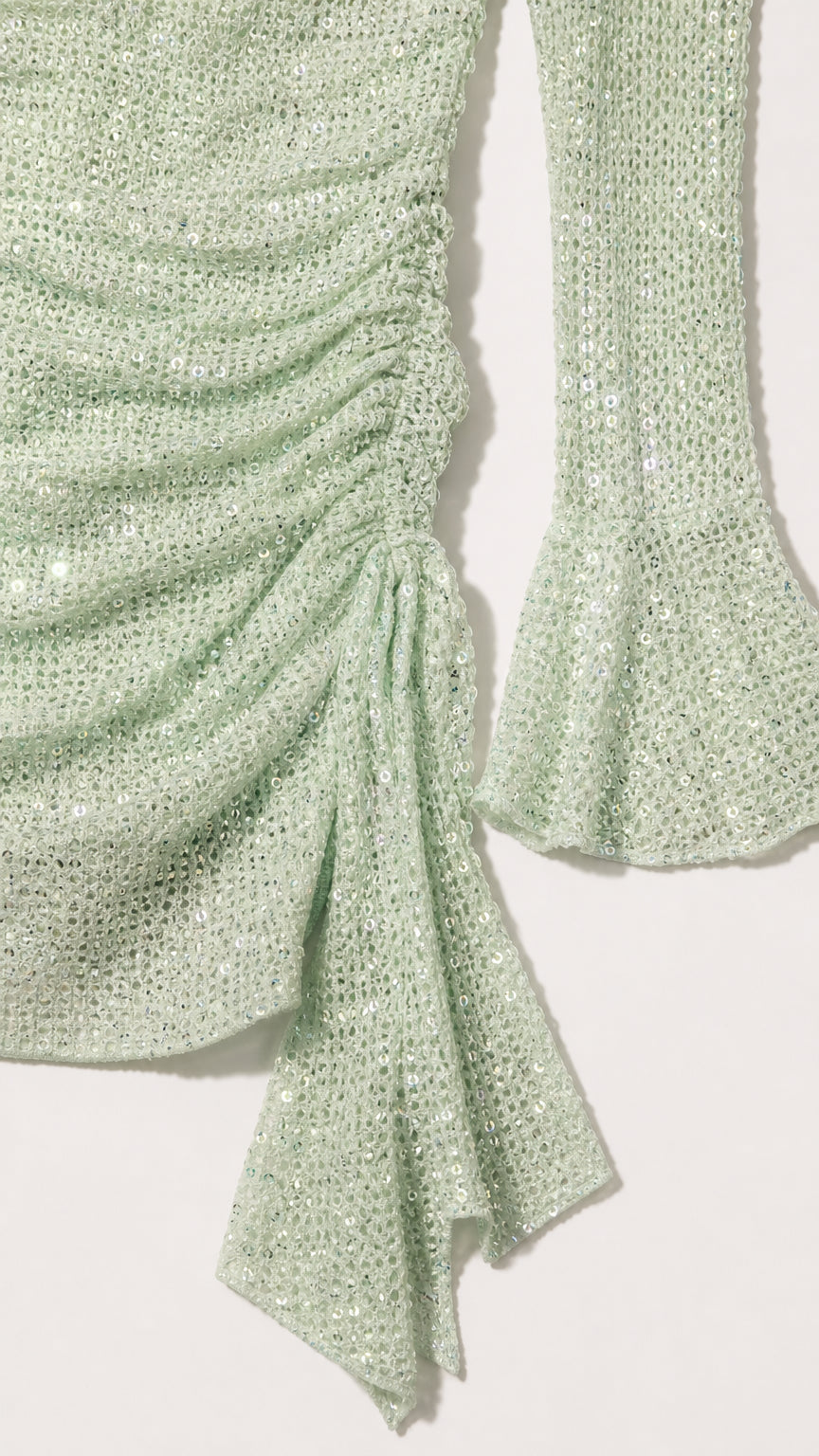 Close-up detail of sage green shimmer fabric, ruching, and flared cuff