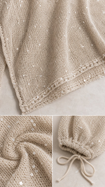 Close-up details of shimmering open-knit sequin fabric and tie cuff detail
