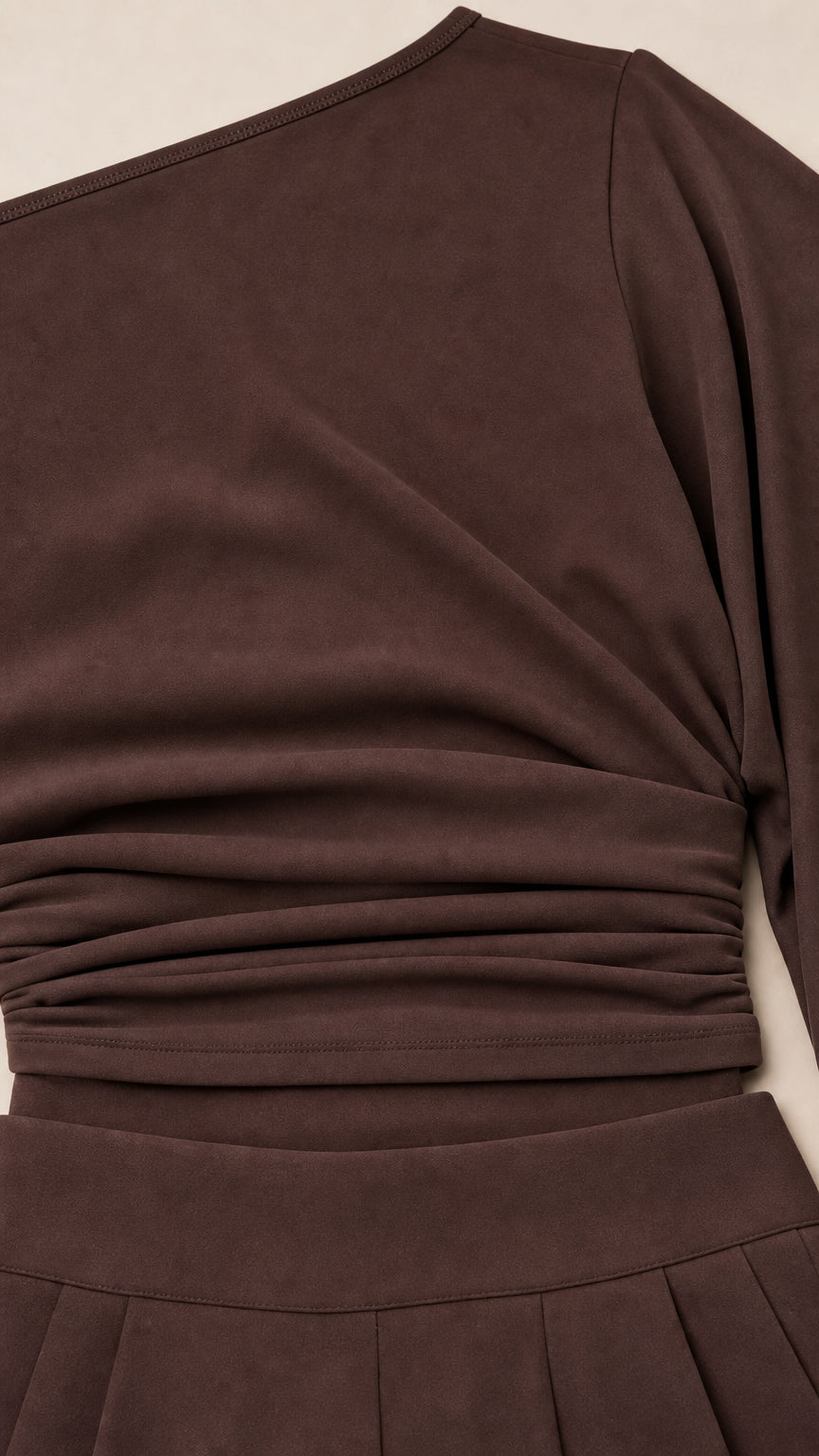 Close-up detail of chocolate brown ruched waistband and smooth knit fabric
