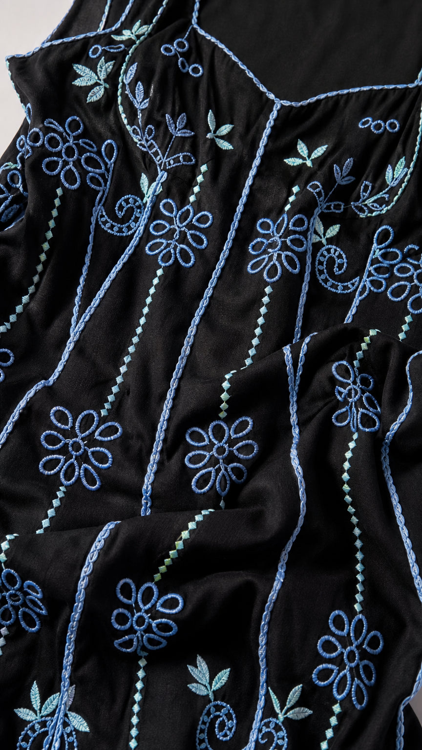 Close-up detail of blue floral embroidery on black fabric