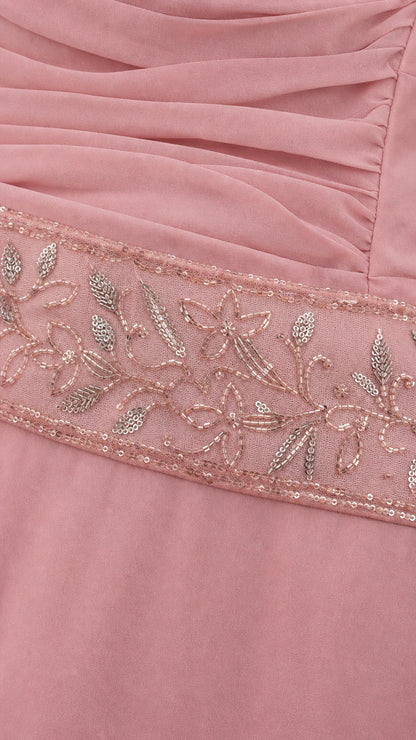Close-up detail of delicate floral beadwork and pleating on dusty rose dress waist
