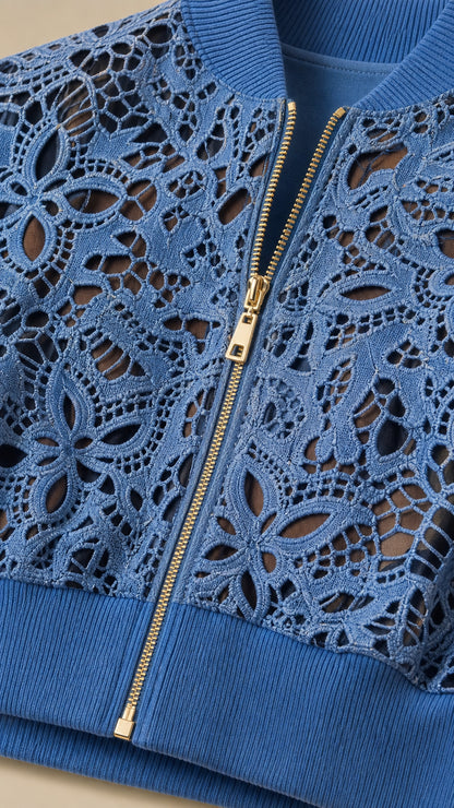 Detailed close-up of blue floral cutout lace bomber jacket with gold zipper