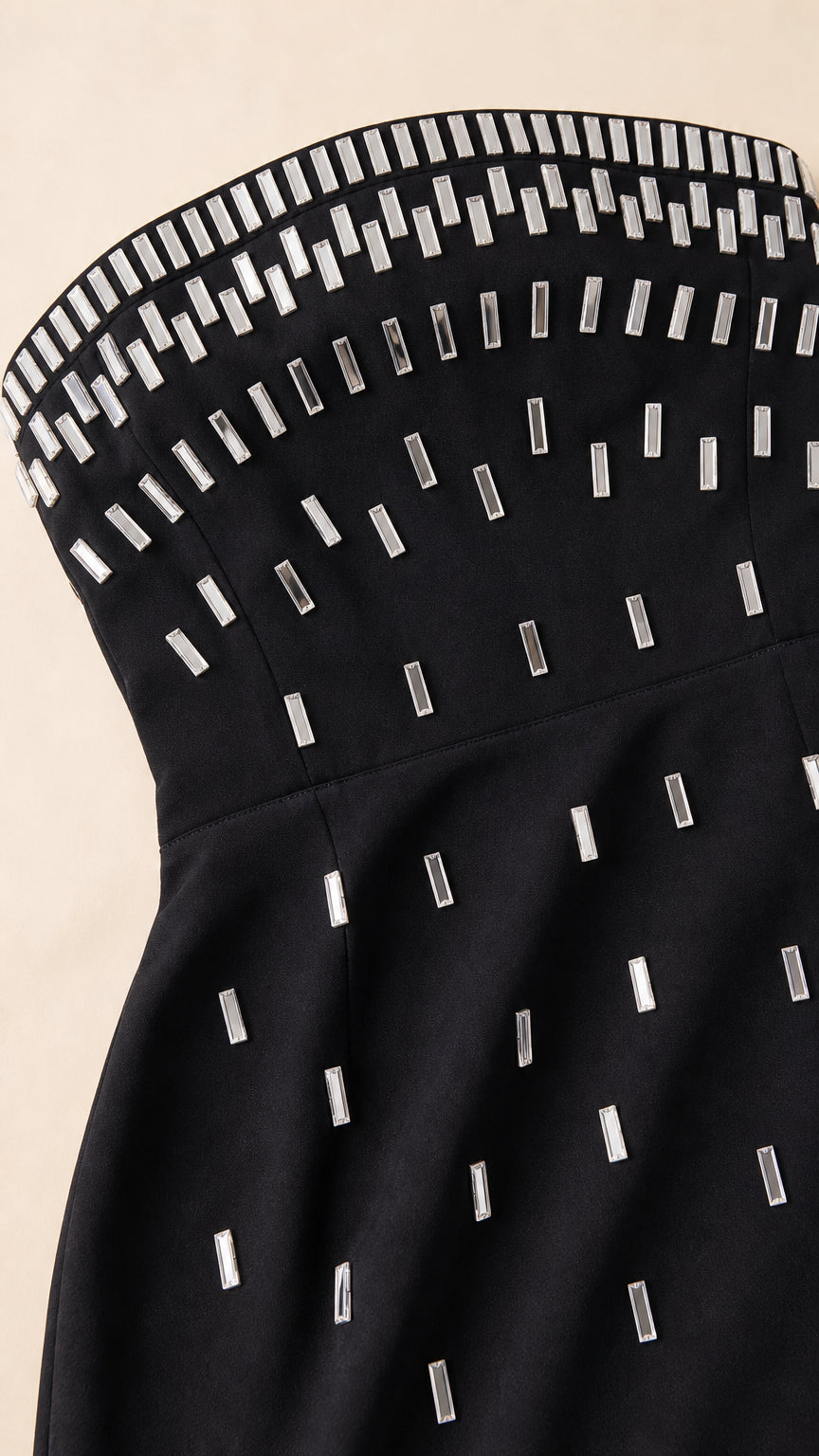 Close-up detail of geometric silver rhinestone embellishments on black dress bodice