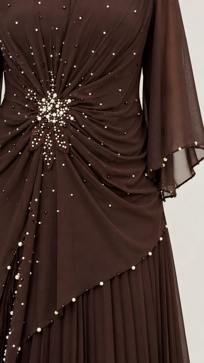 Close-up detail of pearl and bead starburst embellishments on dark brown chiffon bodice
