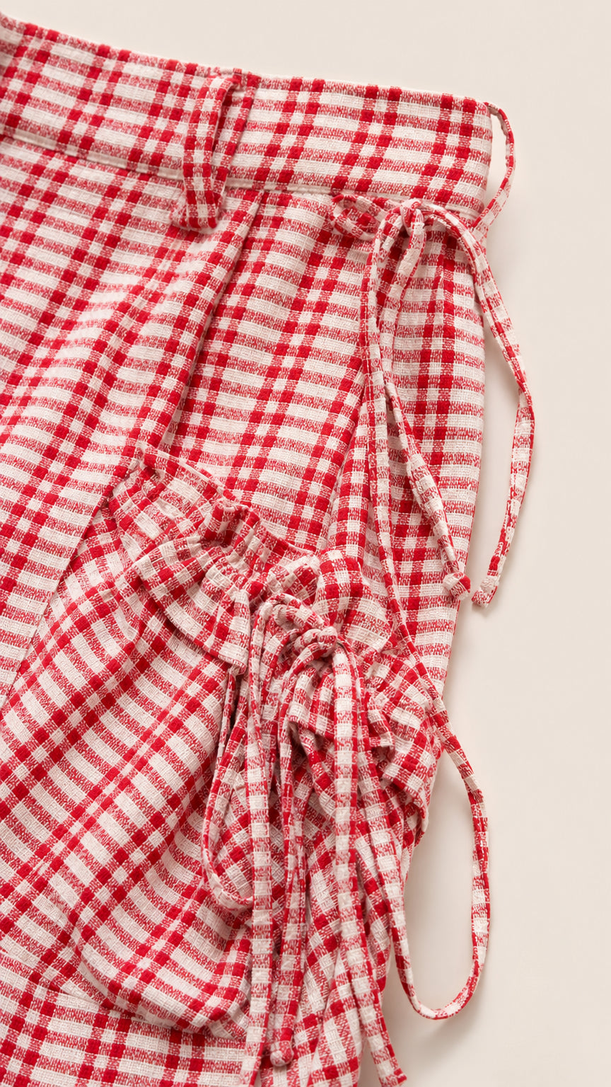 Close-up detail of red gingham check fabric with ruched drawstring ties