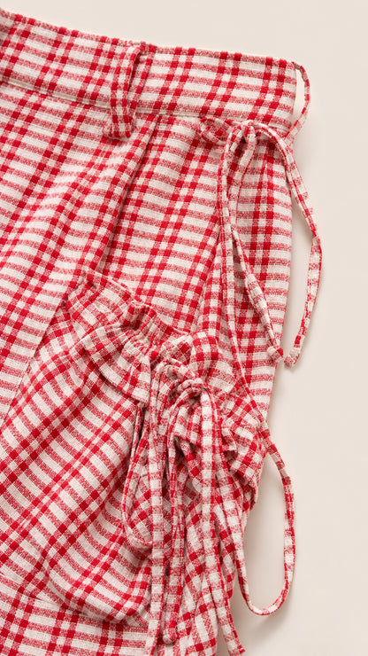 Close-up detail of red gingham check fabric with ruched drawstring ties