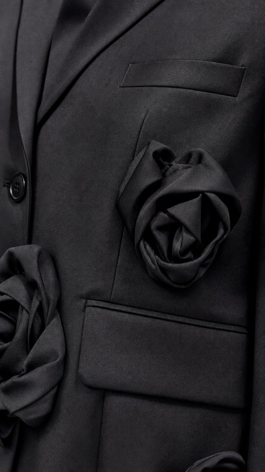 Close-up detail of black fabric rosettes and pocket tailoring on jacket