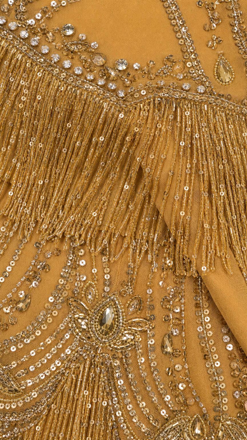 Close-up detail of gold sequin embroidery, crystal accents, and layered tassel fringe