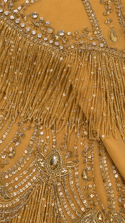 Close-up detail of gold sequin embroidery, crystal accents, and layered tassel fringe