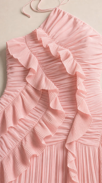 Close-up detail of blush pink pleated chiffon fabric with ruffle trim