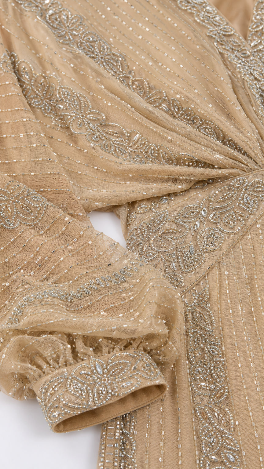 Close-up detail of embellished fabric, sequins, and sleeve cuff on Champagne Gold gown