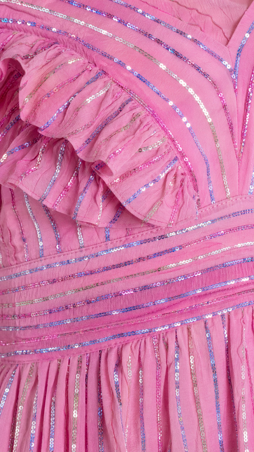 Close-up detail of ruffles and sequin stripe texture on pink dress