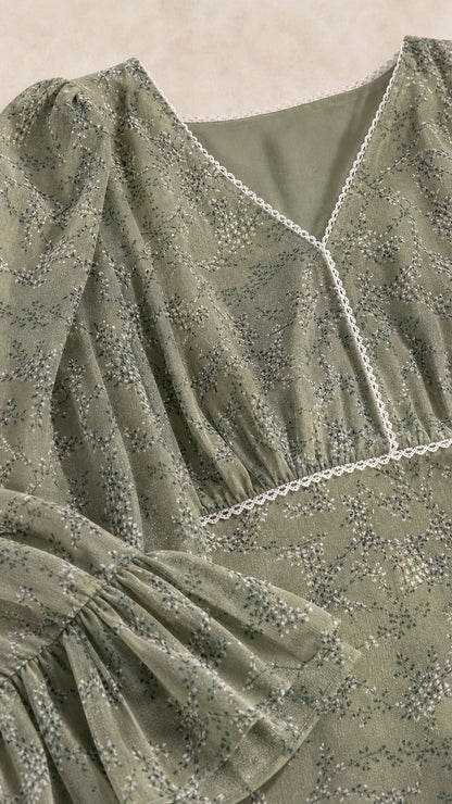 Close-up of sage green floral print fabric with lace V-neckline and ruffled sleeve detail